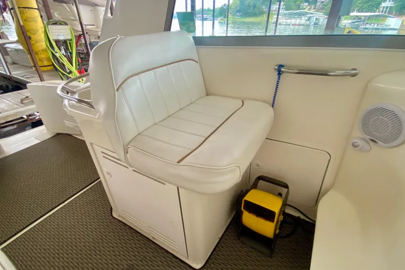 Slide: The Image of 1997 Sea Ray 330 Sundancer interior with white seating and lake view. - 10