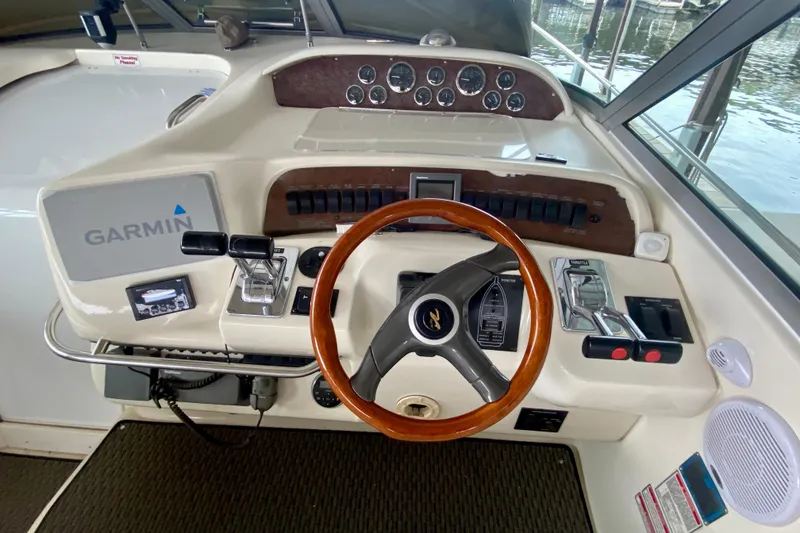 Slide: The Image of 1997 Sea Ray 330 Sundancer helm with Garmin navigation and wood-accented steering wheel. - 14