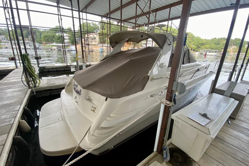 Slide: The Image of 1997 Sea Ray 330 Sundancer docked under a covered marina, rear view. - 2