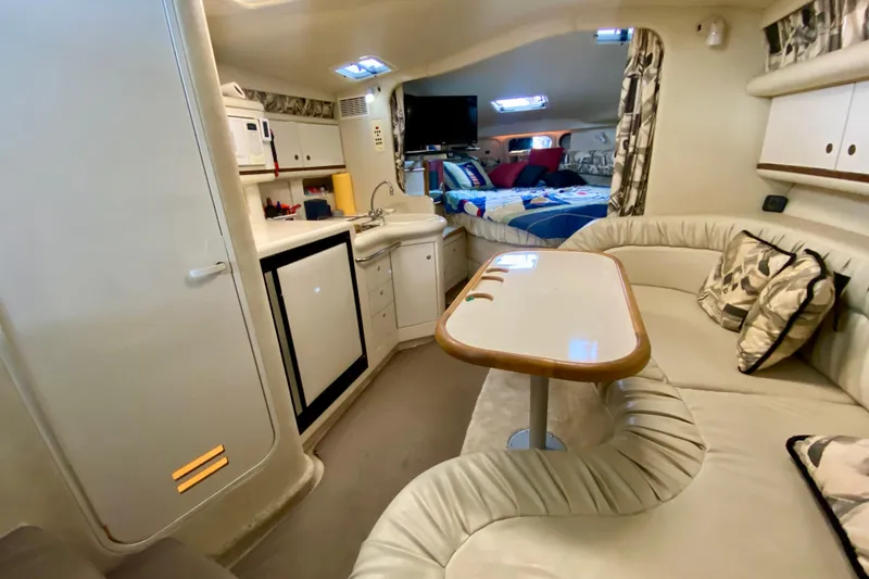 Slide: The Image of Interior of 1997 Sea Ray 330 Sundancer with kitchenette, seating area, and cozy sleeping quarters. - 20
