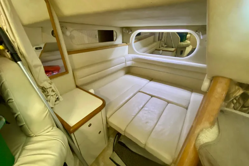 Slide: The Image of 1997 Sea Ray 330 Sundancer cabin interior with beige seating and wooden accents. - 21