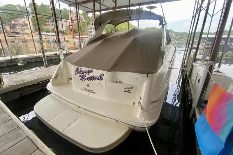 Slide: The Image of 1997 Sea Ray 330 Sundancer docked, covered, with "Change Matters" on the stern. - 3