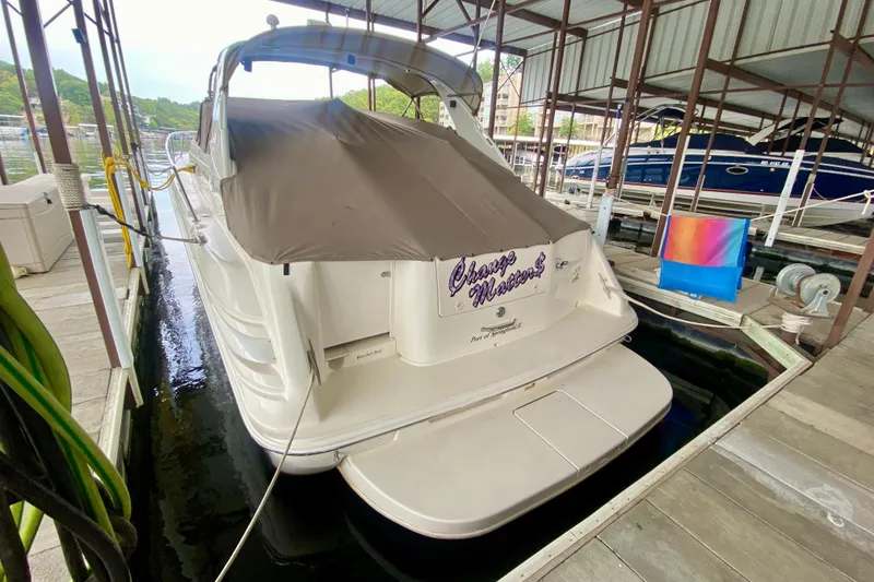 Slide: The Image of 1997 Sea Ray 330 Sundancer docked, covered, with colorful chair nearby. - 4