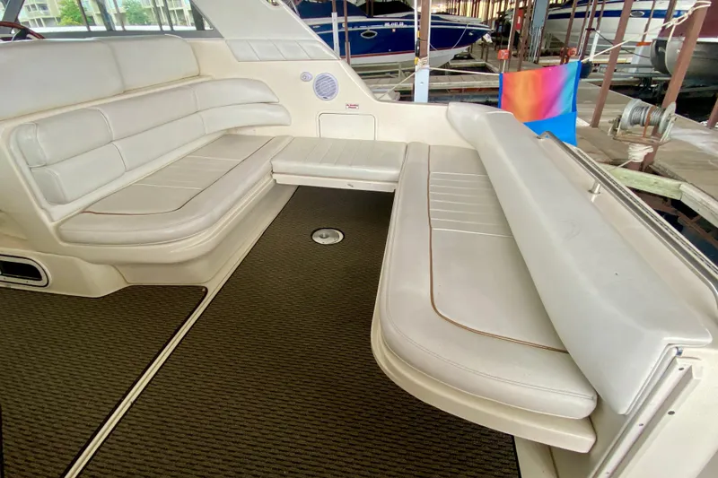 Slide: The Image of 1997 Sea Ray 330 Sundancer interior with white leather seating and carpeted flooring. - 6