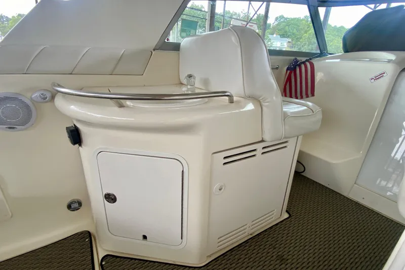 Slide: The Image of 1997 Sea Ray 330 Sundancer cockpit with seating, storage, and American flag decor. - 9