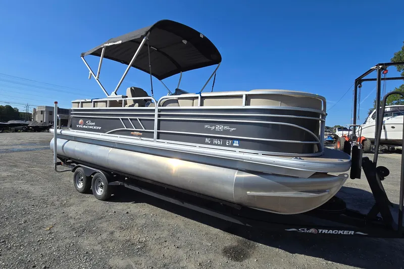 The Image of 2023 Sun Tracker Party Barge 22 RF DLX pontoon boat on trailer, parked outdoors. - 0