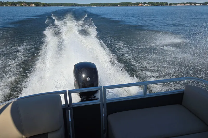 Slide: The Image of 2023 Sun Tracker Party Barge 22 RF DLX cruising on a lake, leaving a wake. - 11