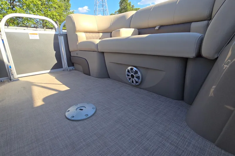 Slide: The Image of 2023 Sun Tracker Party Barge 22 RF DLX interior with beige seating and speaker. - 21