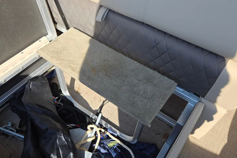 Slide: The Image of 2023 Sun Tracker Party Barge 22 RF DLX interior with carpeted step and storage area. - 34