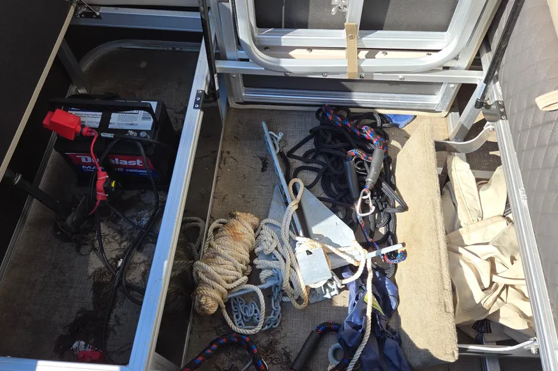 Slide: The Image of Storage compartment of 2023 Sun Tracker Party Barge 22 RF DLX with battery, ropes, and anchor. - 36