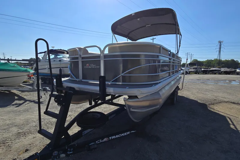 Slide: The Image of 2023 Sun Tracker Party Barge 22 RF DLX pontoon boat on trailer, parked outdoors. - 4