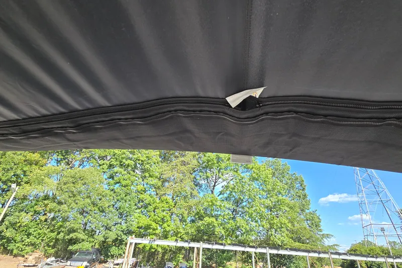 Slide: The Image of 2023 Sun Tracker Party Barge 22 RF DLX canopy with trees and sky in the background. - 67