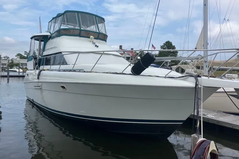 Slide: The Image of 1994 Silverton 41 Aft Cabin yacht docked at a marina under a clear blue sky. - 2