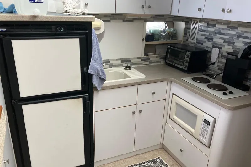 Slide: The Image of Cozy interior of 1994 Silverton 41 Aft Cabin with white seating and nautical decor. - 6