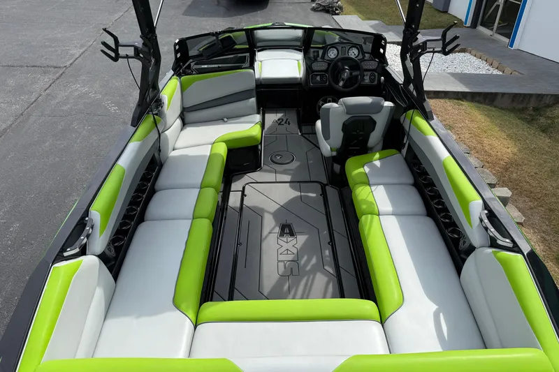 Slide: The Image of 2019 Axis A24 boat interior with green and white seating, modern dashboard, and spacious layout. - 10