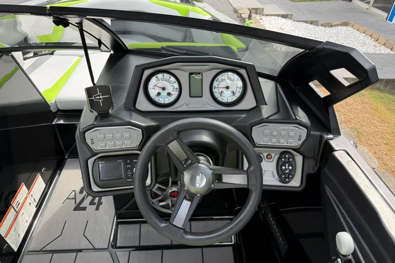 Slide: The Image of 2019 Axis A24 boat dashboard with steering wheel, gauges, and control panels. - 13