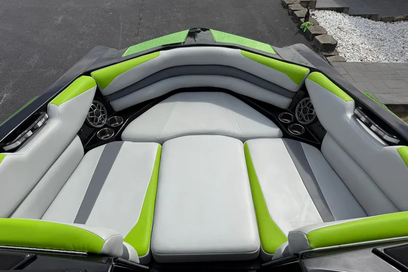 Slide: The Image of 2019 Axis A24 boat interior with green and gray seating, cup holders, and speakers. - 17