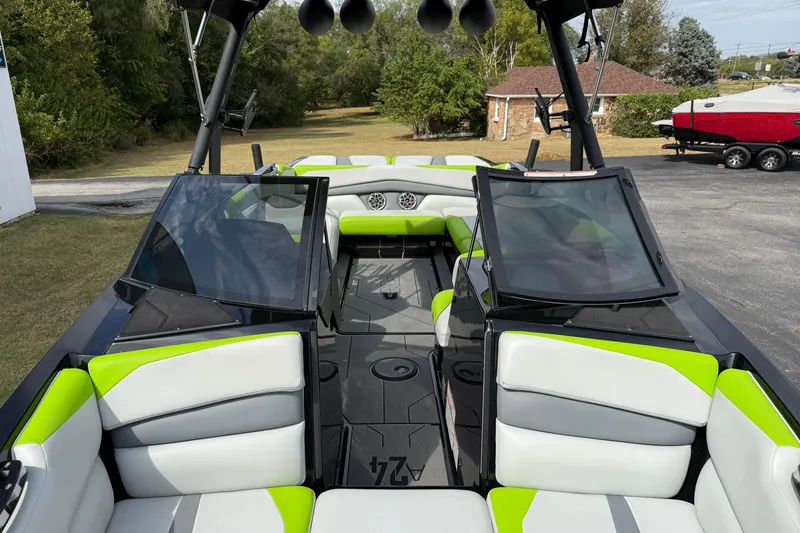 Slide: The Image of 2019 Axis A24 boat interior with green and white seating, open windshield, and tower speakers. - 18