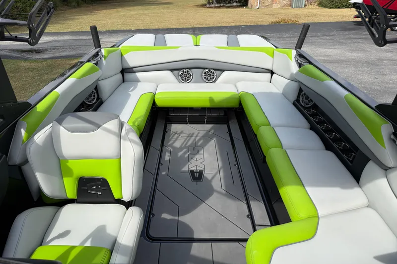Slide: The Image of 2019 Axis A24 boat interior with green and white seating, featuring built-in speakers. - 19