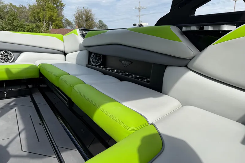 Slide: The Image of 2019 Axis A24 boat interior with green and gray seating, featuring built-in speakers. - 20