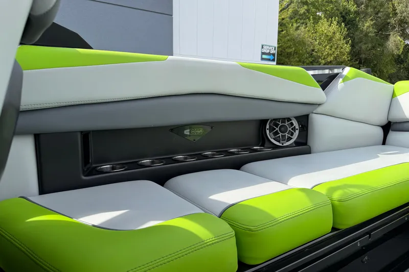 Slide: The Image of 2019 Axis A24 boat interior with lime green and white seating, cup holders, and speaker. - 21