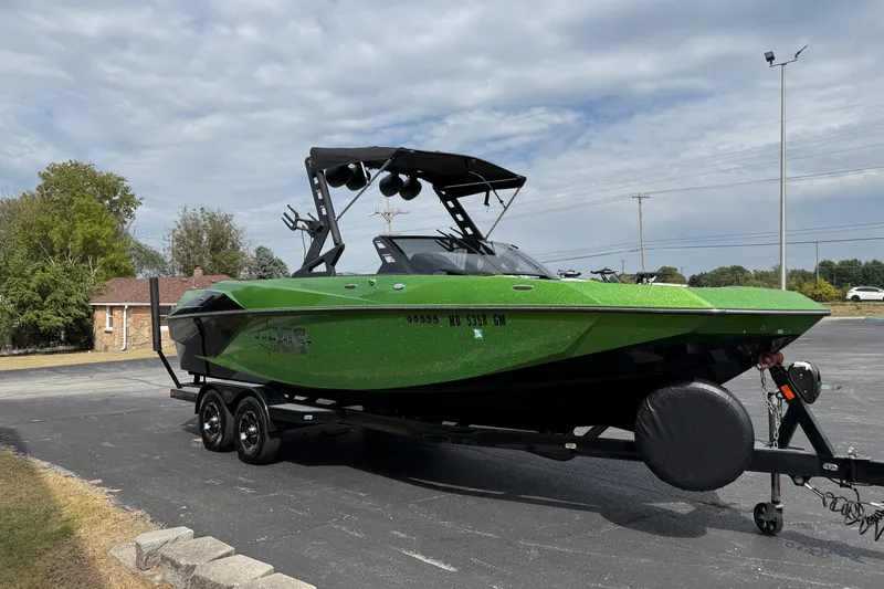 Slide: The Image of 2019 Axis A24 boat in vibrant green on a trailer, parked outdoors. - 3
