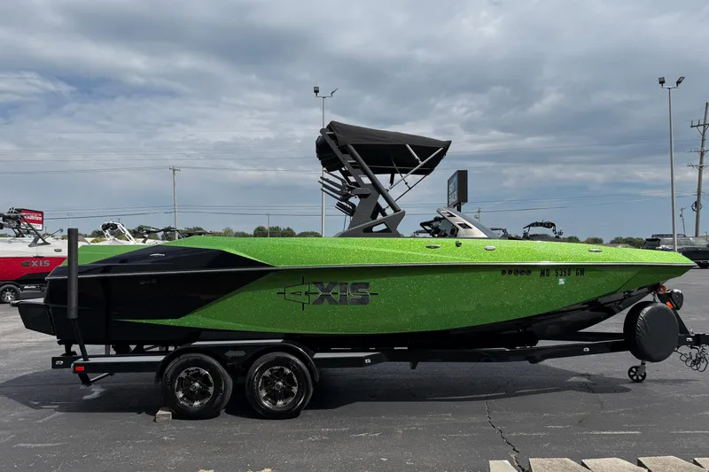 Slide: The Image of 2019 Axis A24 boat in vibrant green on a trailer, parked outdoors. - 4