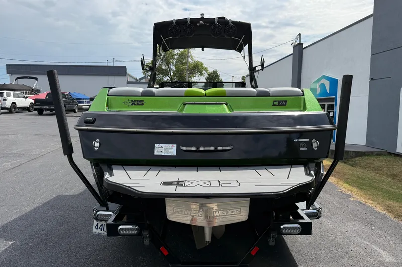 Slide: The Image of 2019 Axis A24 boat with green and black design, parked outdoors. - 7