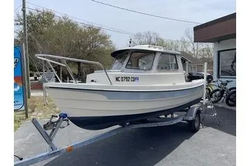 Slide: The Image of 1992 CDory 16 Cruiser boat on trailer, parked outdoors near a building. - 4