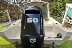 Slide: The Image of 1992 CDory 16 Cruiser with Mercury 50 outboard motor, parked on grass. - 6