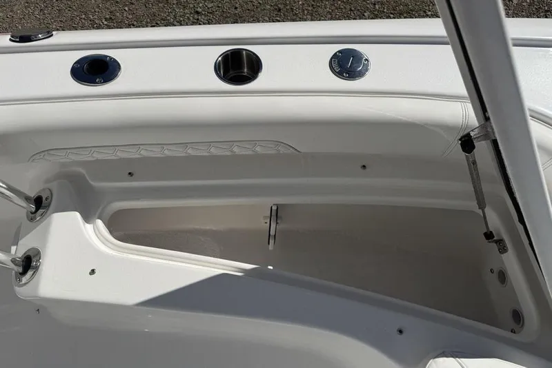 Slide: The Image of 2026 Tidewater 2500 Carolina Bay boat interior storage compartment with cup holders and sleek design. - 15