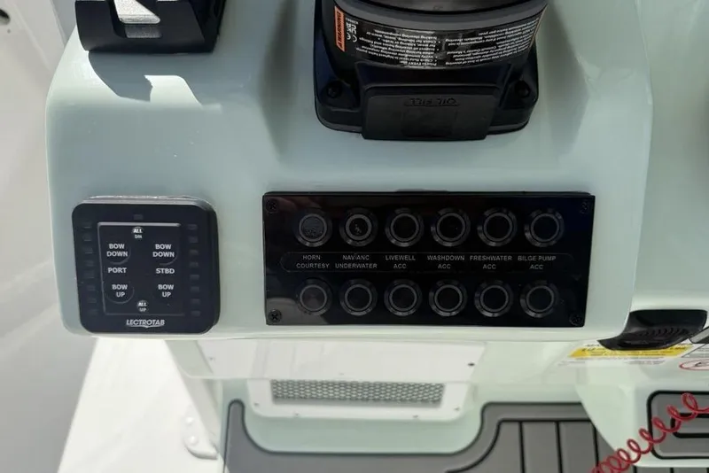 Slide: The Image of Control panel of 2026 Tidewater 2500 Carolina Bay boat with various switches and buttons. - 20