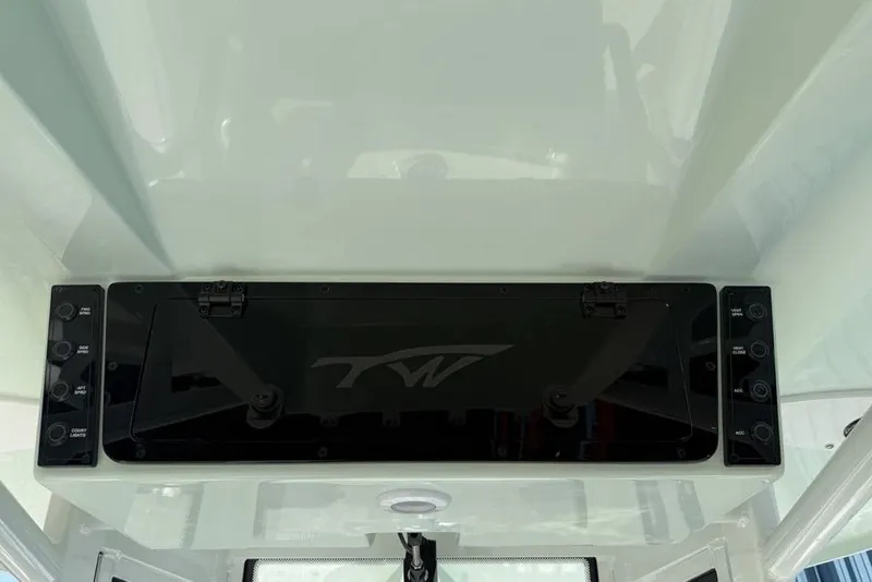 Slide: The Image of 2026 Tidewater 2500 Carolina Bay boat console with control panel and storage compartment. - 24