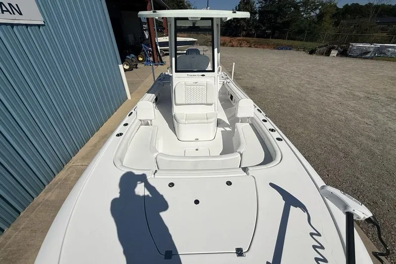 Slide: The Image of 2026 Tidewater 2500 Carolina Bay boat, white deck, parked outdoors near a blue building. - 41
