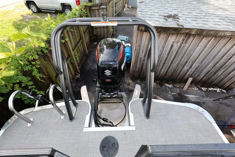 Slide: The Image of 2022 Crest Caribbean Platinum 250SLRC boat with Suzuki outboard motor, docked near wooden fence. - 18