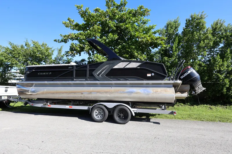 Slide: The Image of 2022 Crest Caribbean Platinum 250SLRC pontoon boat on trailer, parked outdoors. - 3