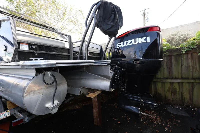 Slide: The Image of 2022 Crest Caribbean Platinum 250SLRC boat with Suzuki outboard motor, parked outdoors. - 5