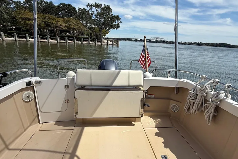Slide: The Image of 2017 Ranger Tugs R-23 boat deck with American flag, docked by calm waters. - 11