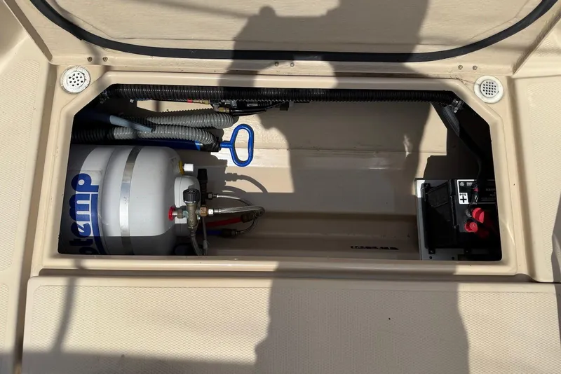 Slide: The Image of 2017 Ranger Tugs R-23 storage compartment with propane tank and battery. - 13