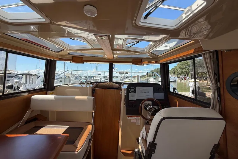 Slide: The Image of Interior of 2017 Ranger Tugs R-23 boat with helm, seating, and marina view. - 16