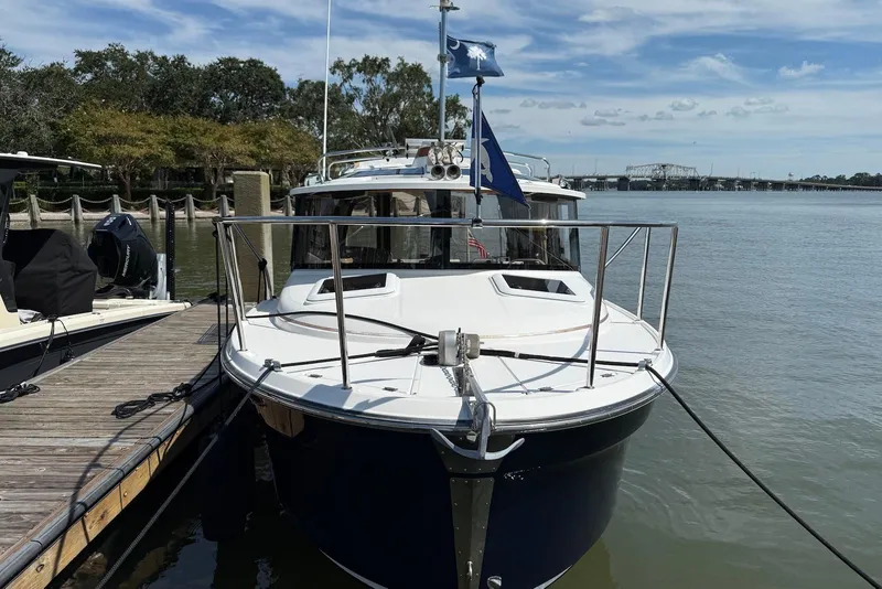 Slide: The Image of 2017 Ranger Tugs R-23 boat docked by a wooden pier on a sunny day. - 2