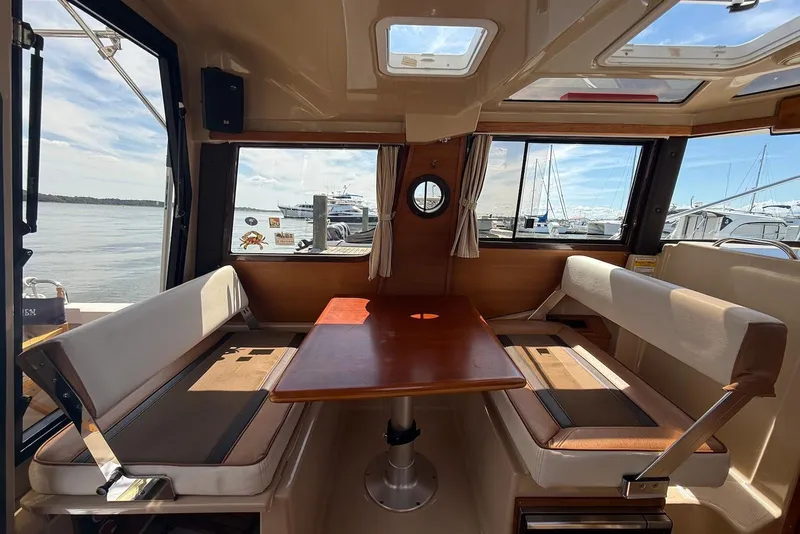 Slide: The Image of Interior of 2017 Ranger Tugs R-23 boat with seating and table, docked at marina. - 22