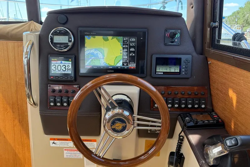 Slide: The Image of 2017 Ranger Tugs R-23 helm with navigation screens and wooden steering wheel. - 25