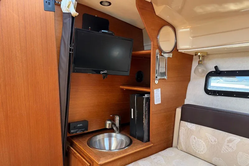 Slide: The Image of Interior of 2017 Ranger Tugs R-23 boat with TV, sink, and seating area. - 26