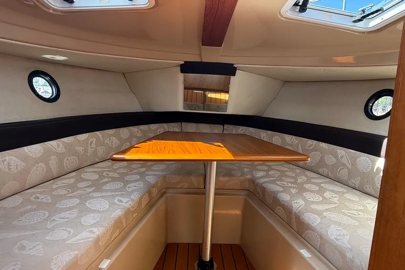 Slide: The Image of 2017 Ranger Tugs R-23 cabin interior with cushioned seating and wooden table. - 27