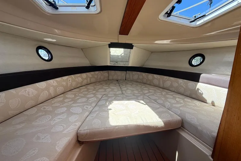 Slide: The Image of 2017 Ranger Tugs R-23 cabin interior with patterned cushions and porthole windows. - 28