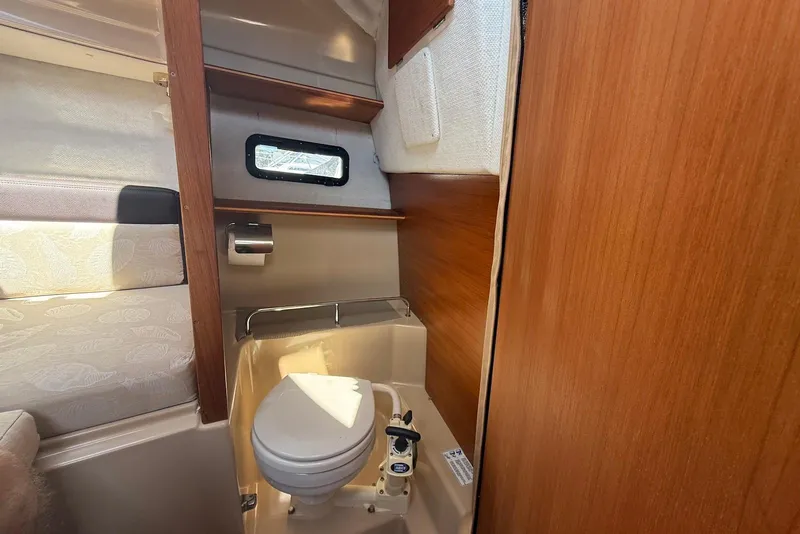 Slide: The Image of 2017 Ranger Tugs R-23 boat interior with compact marine toilet and wooden paneling. - 29