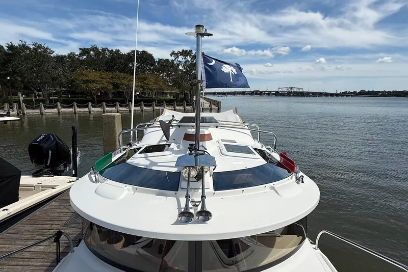 Slide: The Image of 2017 Ranger Tugs R-23 boat docked by a scenic waterfront with a flag. - 3