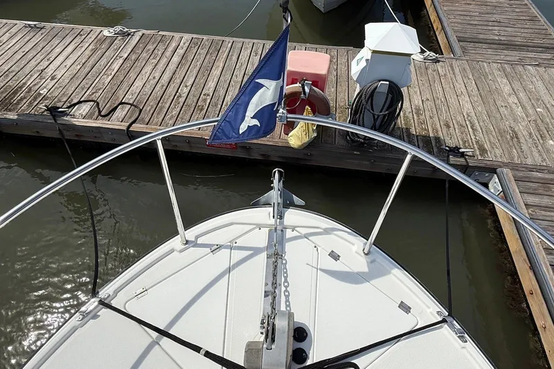 Slide: The Image of Bow view of 2017 Ranger Tugs R-23 docked, featuring anchor and flag. - 5