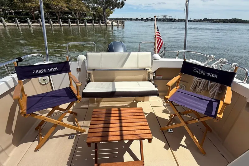 Slide: The Image of 2017 Ranger Tugs R-23 boat deck with chairs, table, and water view. - 9